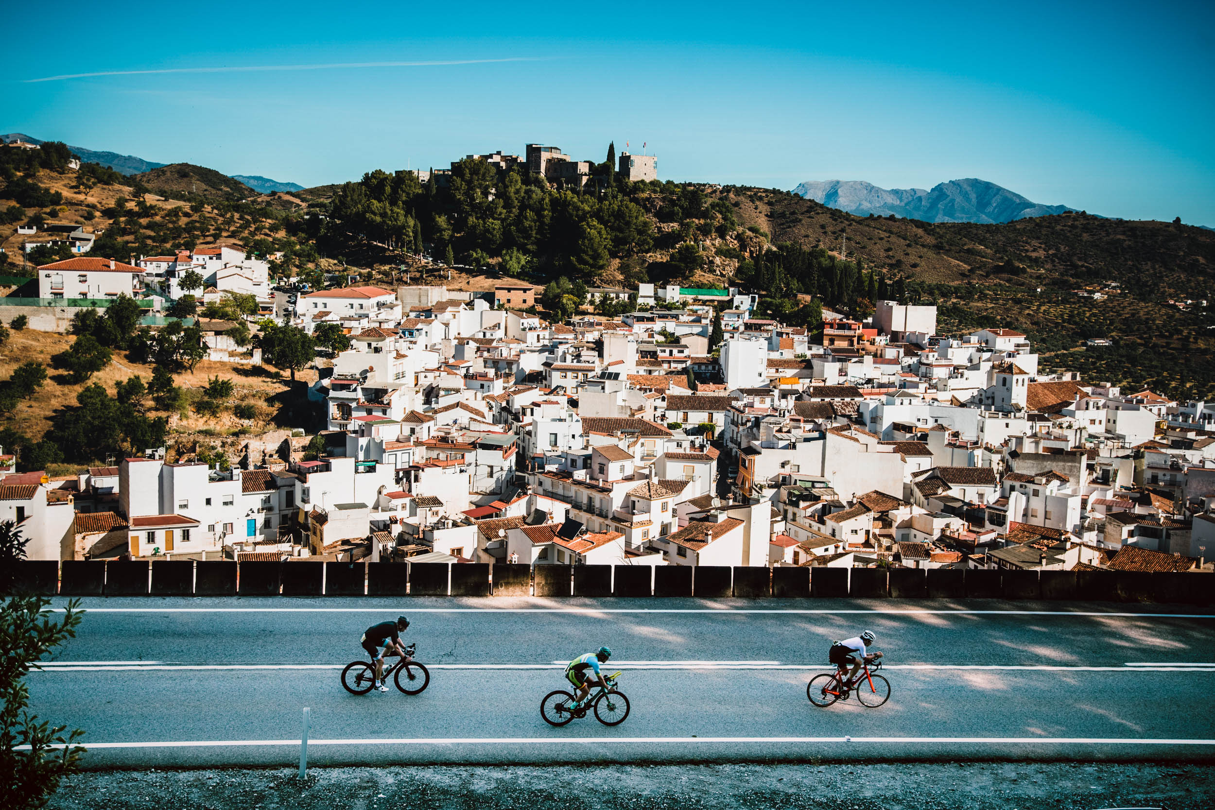 Radfahrer vor der Kulisse eines Bergdorfs im Hinterland von Marbella