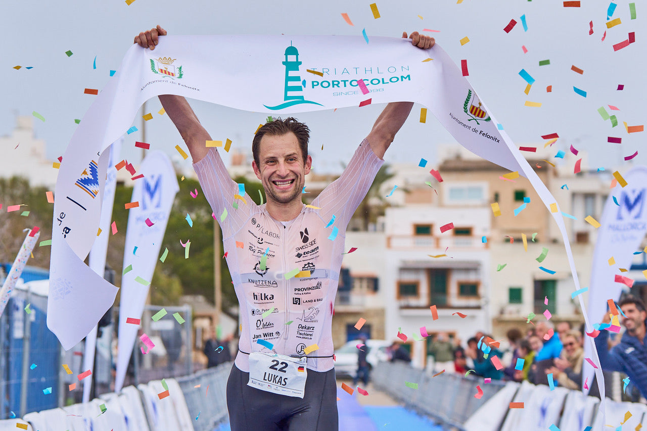 Lukas Schnödewind siegt beim Portocolom Triathlon 2026 auf Mallorca und lacht glücklich in die Kamera.
