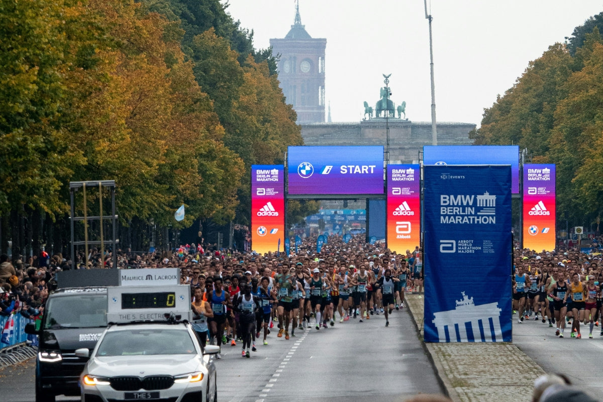 Eine Gruppe von Marathonläufern läuft auf der Straße kurz nach dem Start des BMW Berlin Marathons.